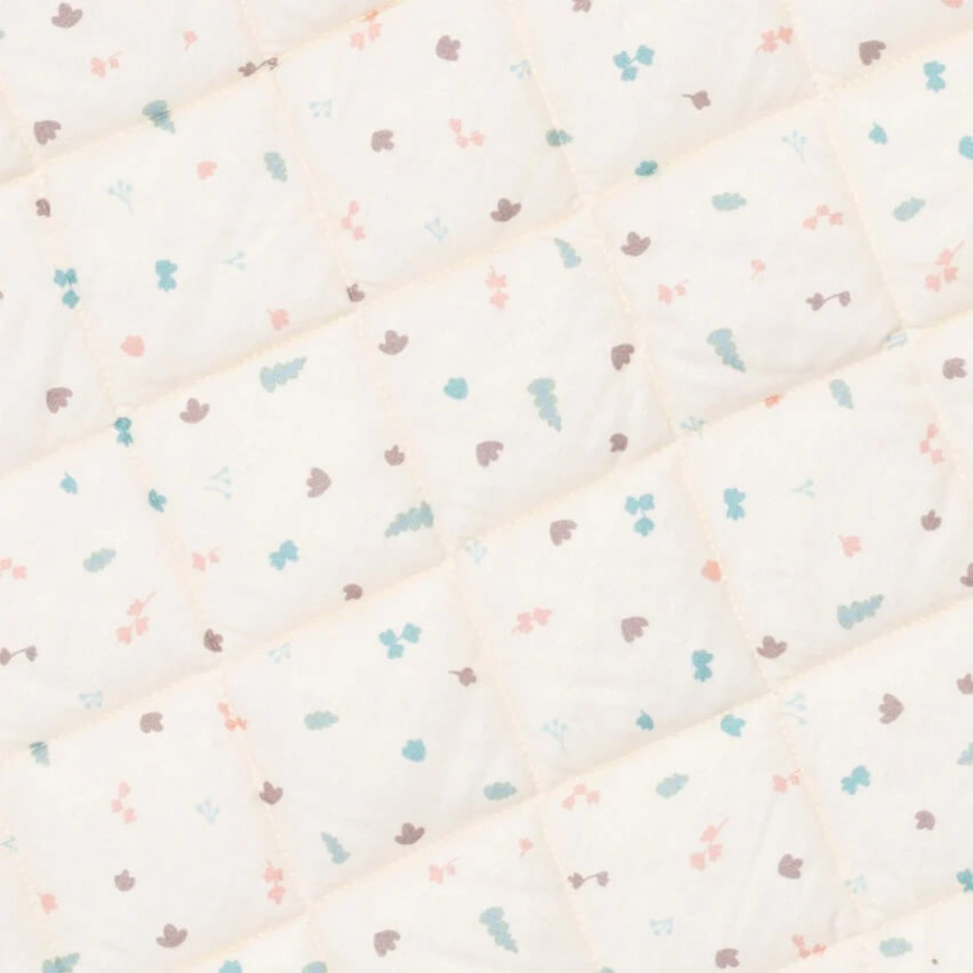 A close-up view of the padded quilted fabric showing diamond stitching and a small repeating pastel print.