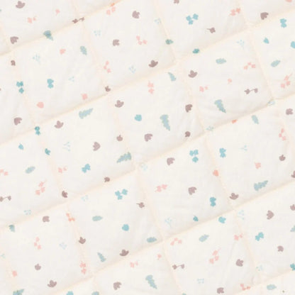 A close-up view of the padded quilted fabric showing diamond stitching and a small repeating pastel print.