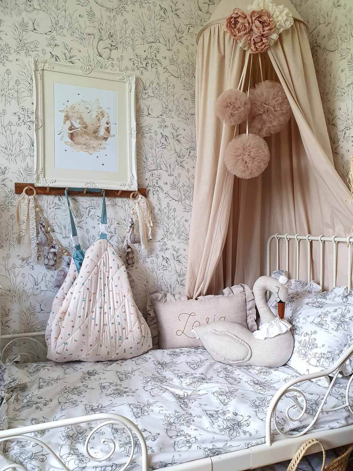 A nursery scene showing a soft play mat used on a bedroom floor with wooden toys, soft furnishings and woven storage baskets.