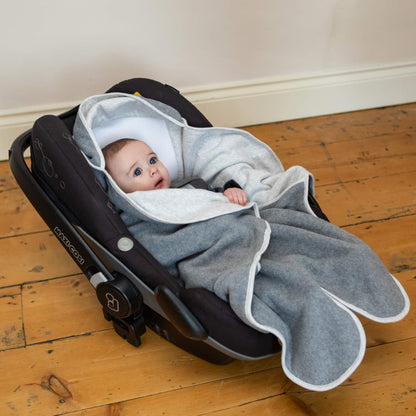 Baby seated in a car seat with hooded light grey blanket fabric positioned behind the head and fleece panels resting forward.
