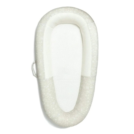 Purflo Sleep Tight Baby Bed, top-down view showing a breathable mesh mattress base and softly structured sides in a pale botanical print.