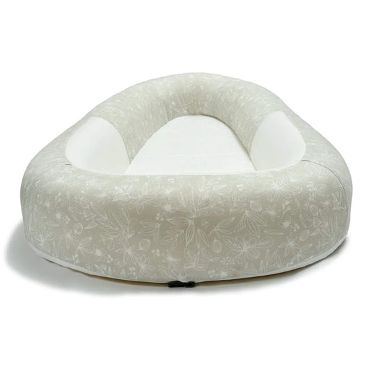 A side view of a baby bed with raised, structured sides and a firm, flat mesh sleeping surface.
