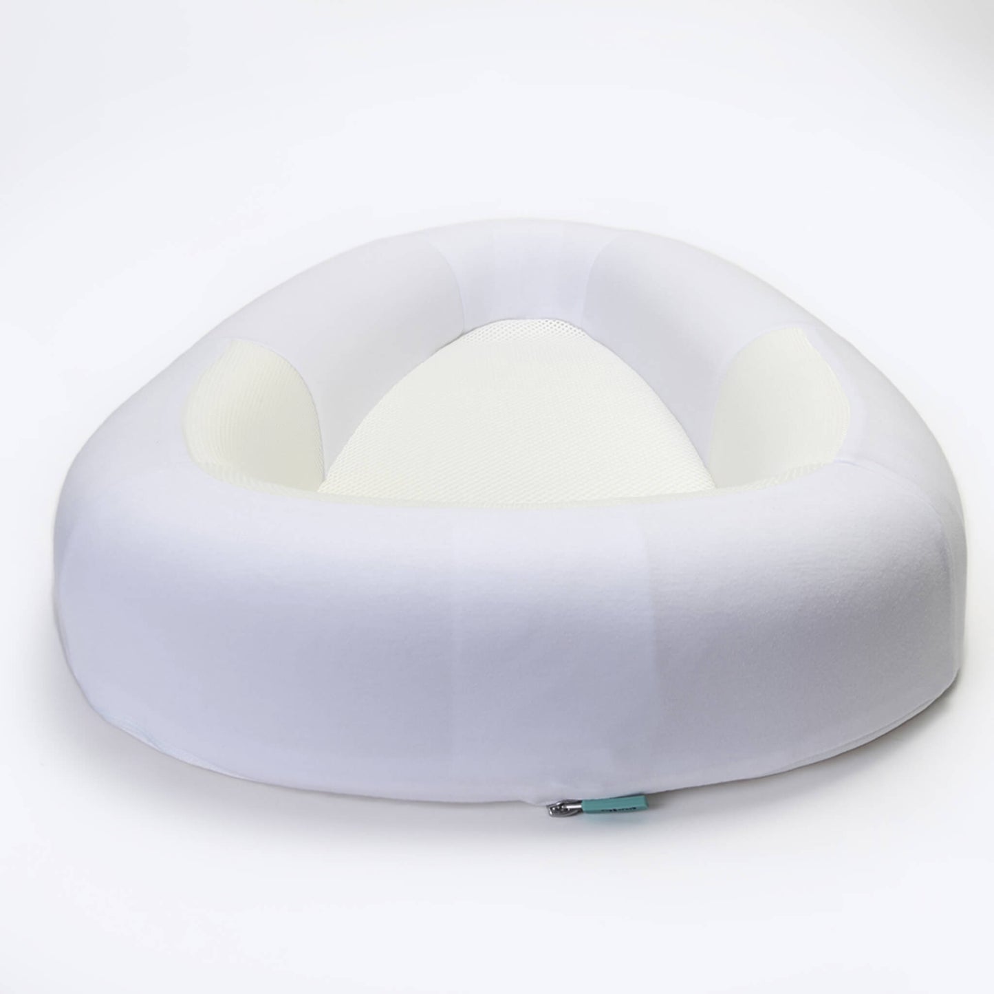 A baby bed with softly structured sides and a breathable mesh base, shown from a low angle to highlight the open, cushioned shape.