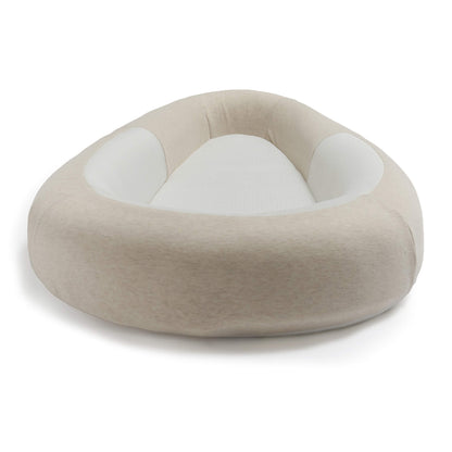 A front view of a baby bed showing the raised padded surround and breathable mesh mattress.