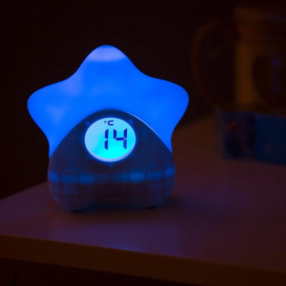 Star-shaped room thermometer glowing blue with digital temperature display reading 14°C in low light.
