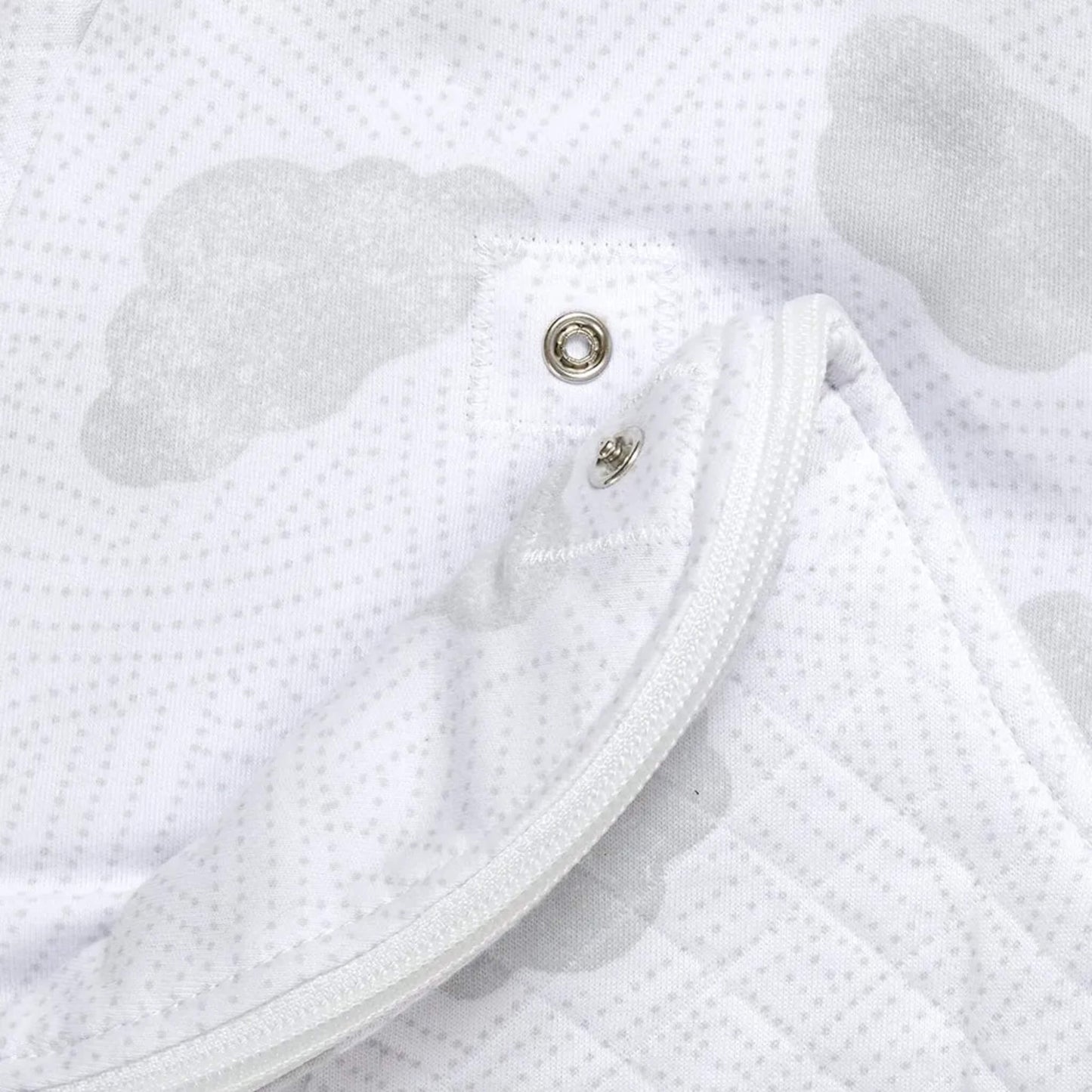 Close-up of lower zip and press-stud fastening used for nappy changes without fully removing bag.