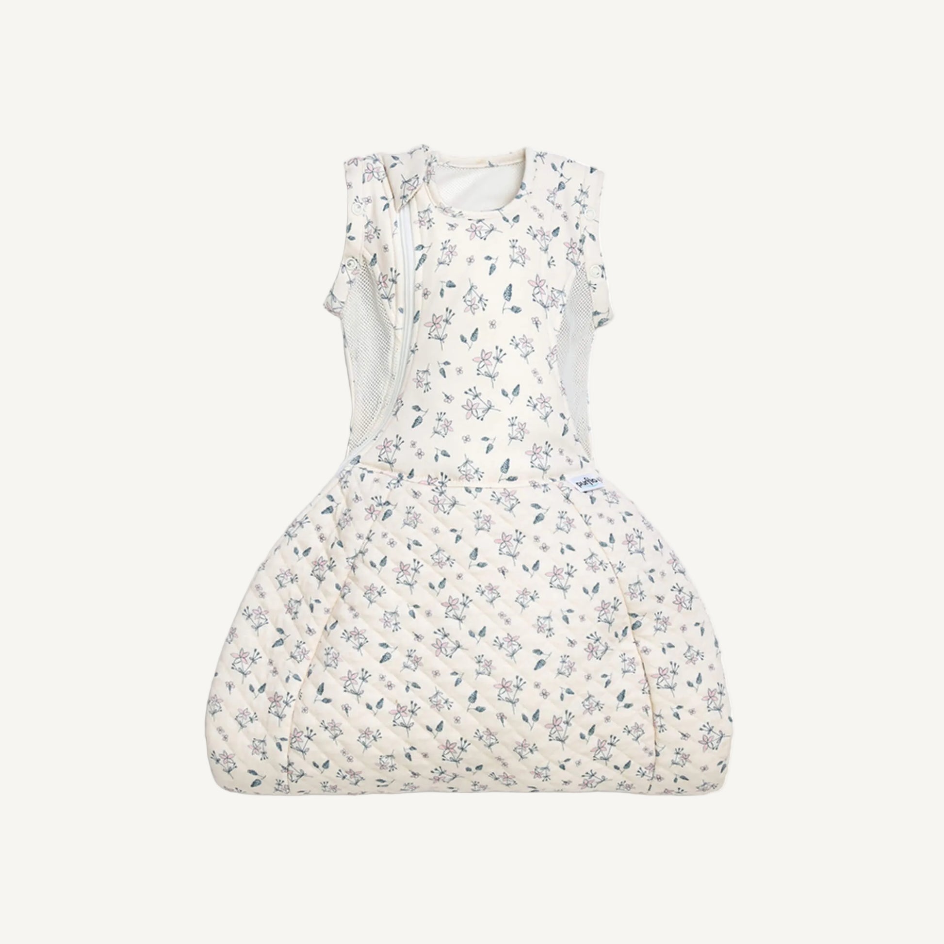 A swaddle to sleep bag laid flat with the lower section fully closed, showing the quilted fabric and curved hip-healthy shape.