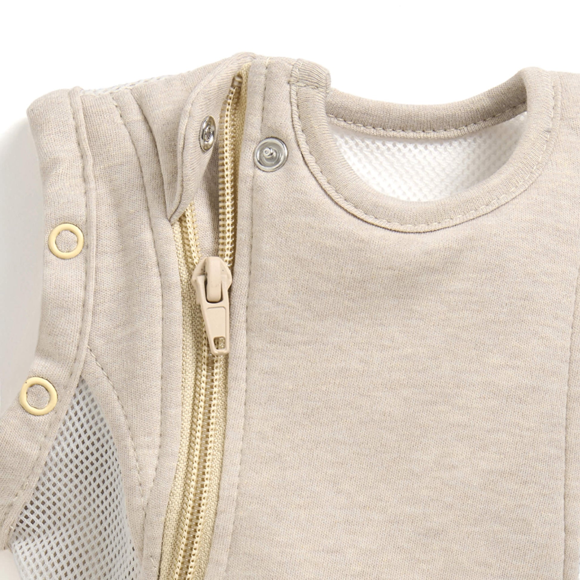 A close-up of a concealed zip with a fabric guard near the neckline of a baby sleep bag.