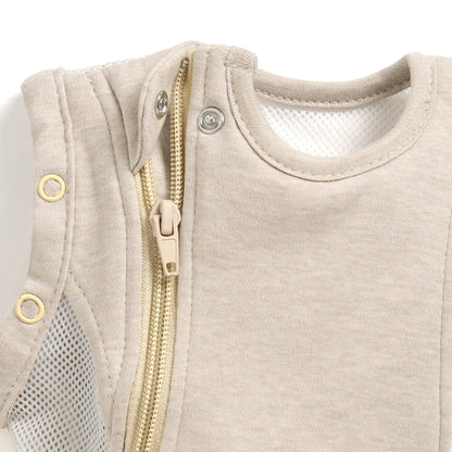 A close-up of a concealed zip with a fabric guard near the neckline of a baby sleep bag.