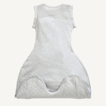 A front view of a minimal grey swaddle sleep bag showing breathable mesh side panels, a curved zip opening, and a softly contoured lower section for natural leg movement.