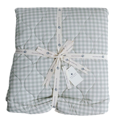 Ralphie Bear quilted playmat in sage green gingham, softly padded and folded with branded ribbon, showing stitched quilting detail and cushioned design.