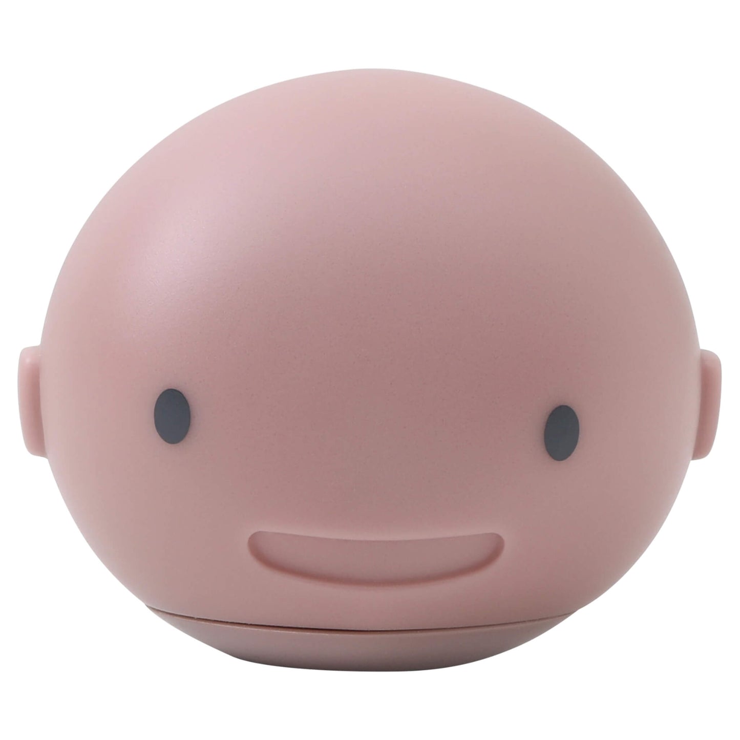 A pale pink whale-shaped bath toy with a smiling face, viewed from the front against a plain background.