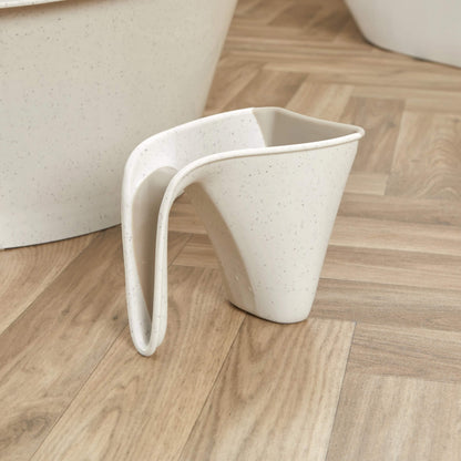 Cream jug placed on a wooden floor beside a matching baby bath, showing its compact size.