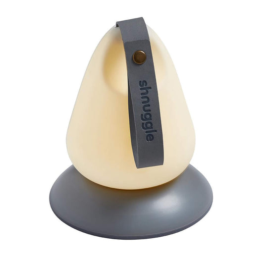 The Shnuggle Moonlight Nightlight, a portable pear-shaped nursery light with soft glow and carry handle, shown on its grey charging base.