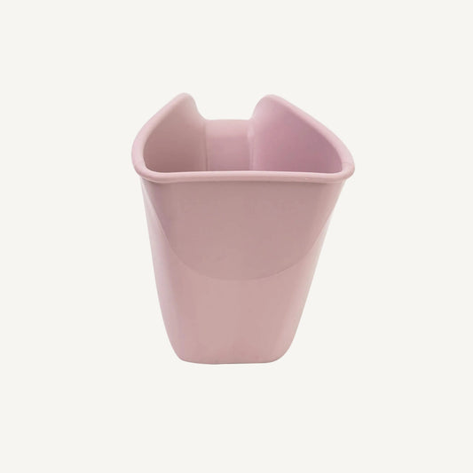 A pink plastic rinsing jug shown from the front, highlighting the curved pouring edge and open top design for controlled water flow.
