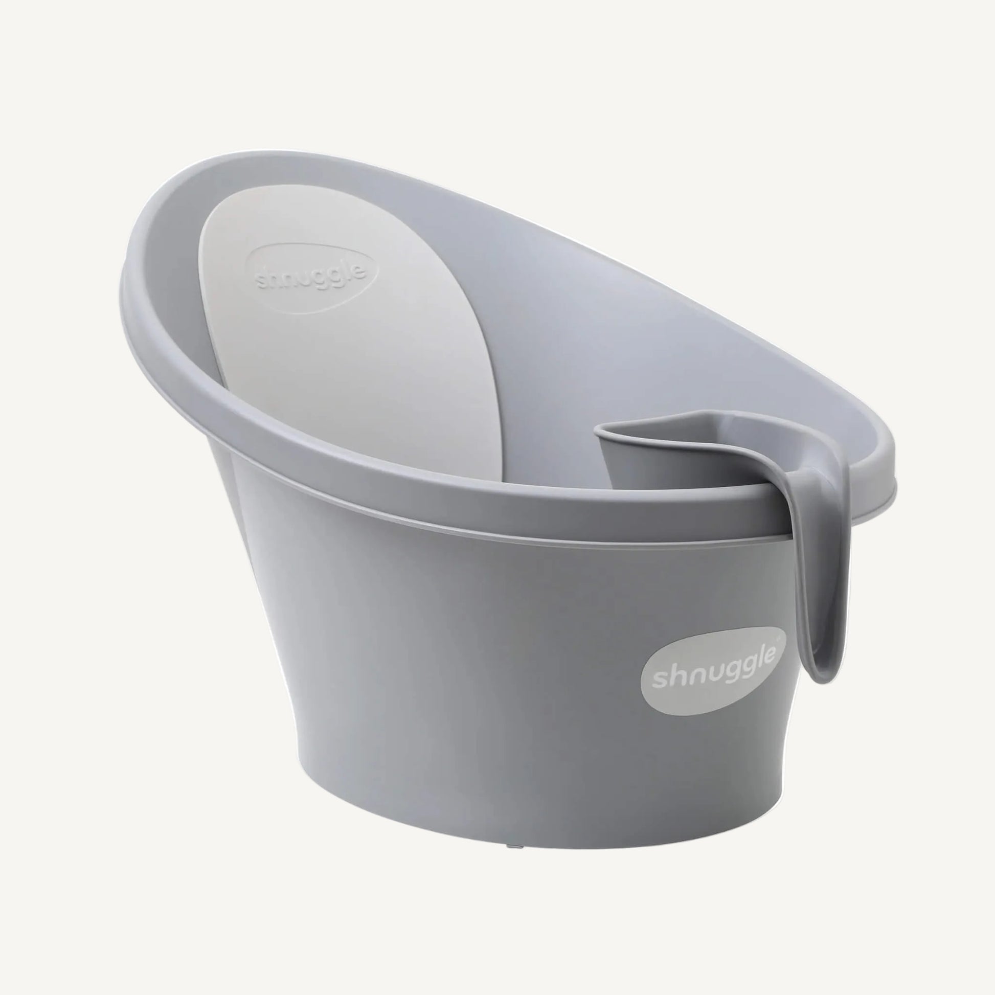 A grey rinsing jug hooked onto the rim of a baby bath, showing compact storage within easy reach during bath time.