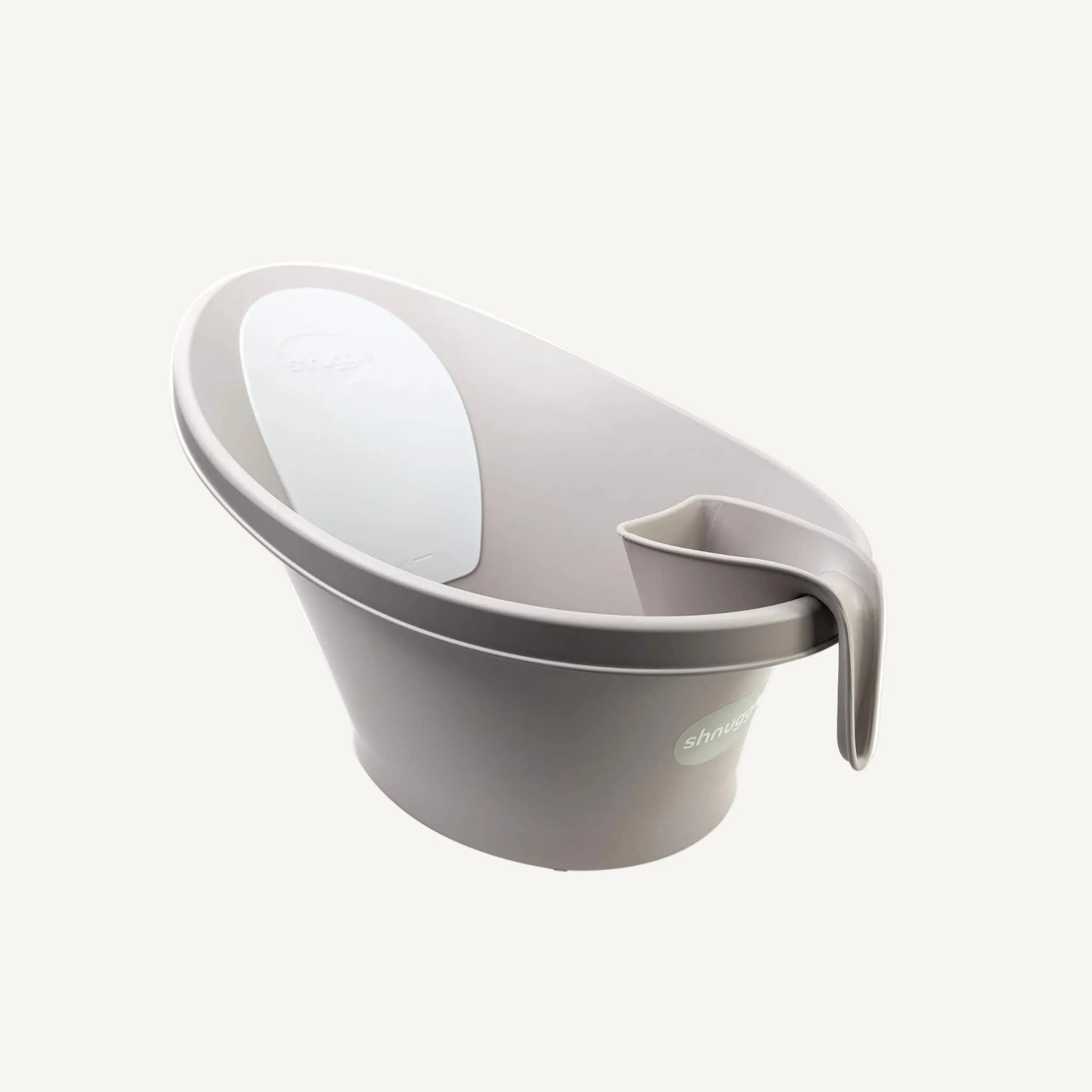 A taupe rinsing jug hooked onto the rim of a baby bath, showing compact storage within easy reach during bath time.