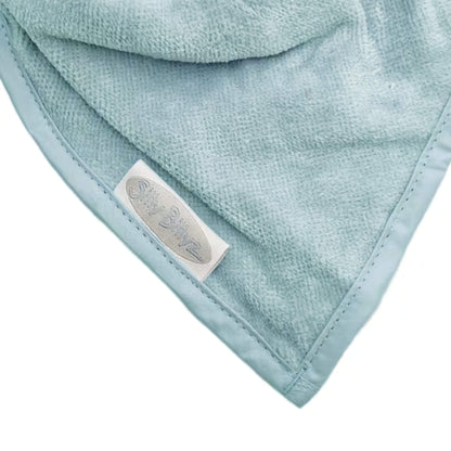 Detail view of soft velour towelling fabric on an aqua bandana bib, highlighting texture and stitched binding along the edge.