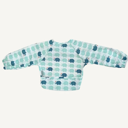 A long-sleeve bib in a repeating elephant pattern shown laid flat from the back, with elasticated cuffs and a smooth wipe-clean surface.