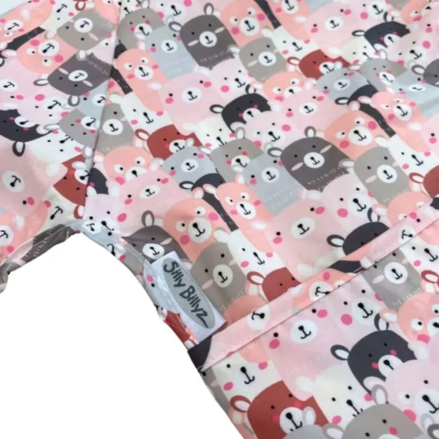 Close-up of wipe-clean baby bib fabric showing Peekaboo print with stitched edging and sewn-in brand label.