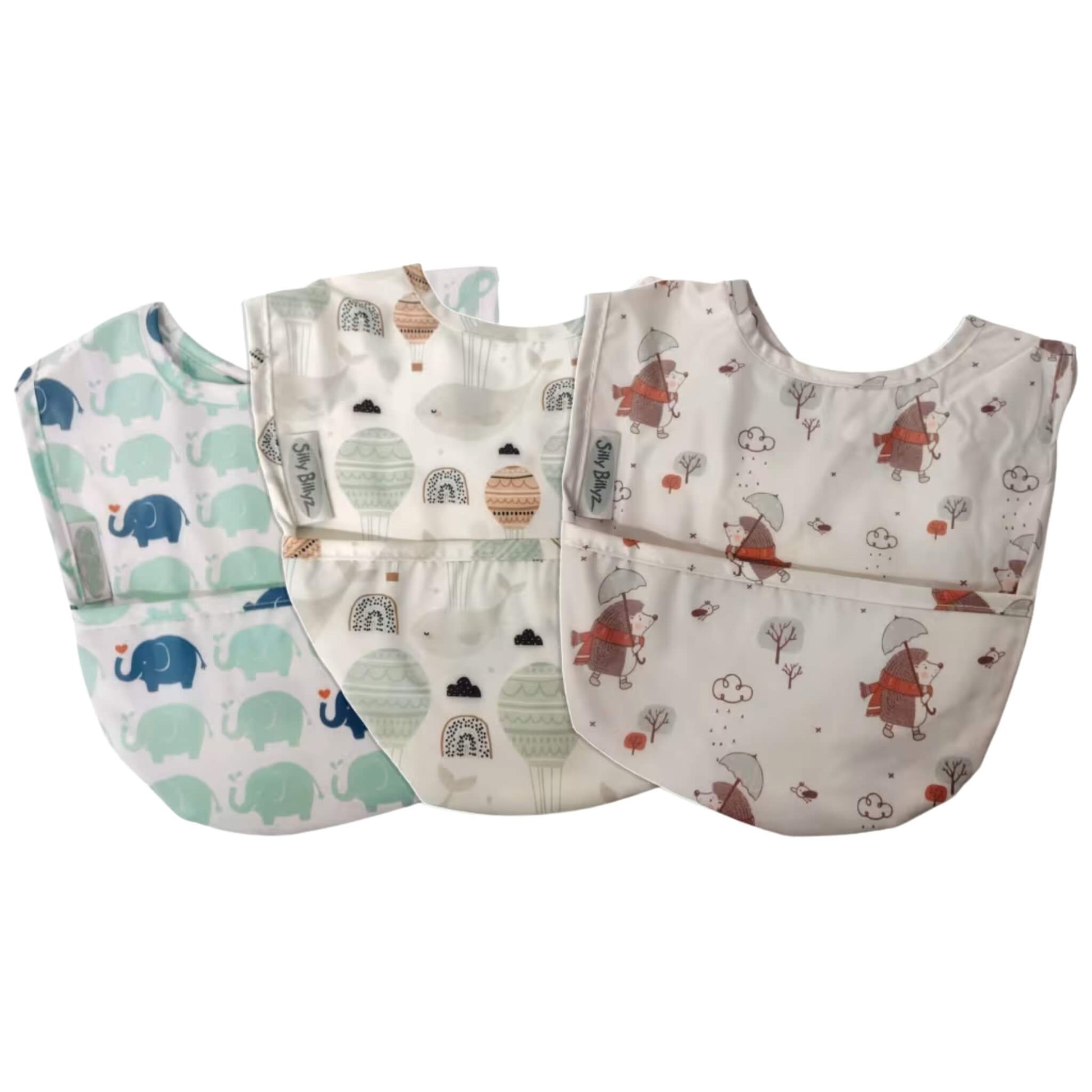 Silly Billyz wipe clean pocket bib 3 pack in varying designs, shown laid flat with soft waterproof fabric, curved shape, and front food-catching pockets.