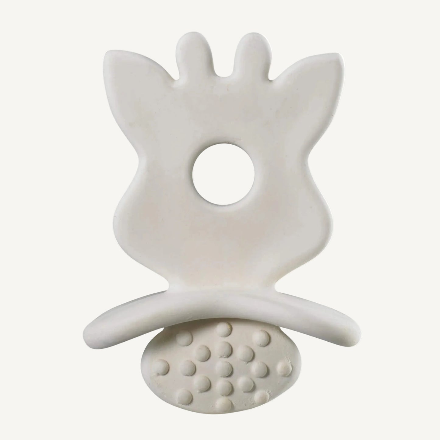 A close-up of a natural rubber leaf-shaped baby teether showing a smooth upper surface, central grip hole, and raised textured dots underneath.