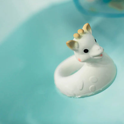 Close-up of a floating giraffe bath toy resting on bath water with ripples around it.