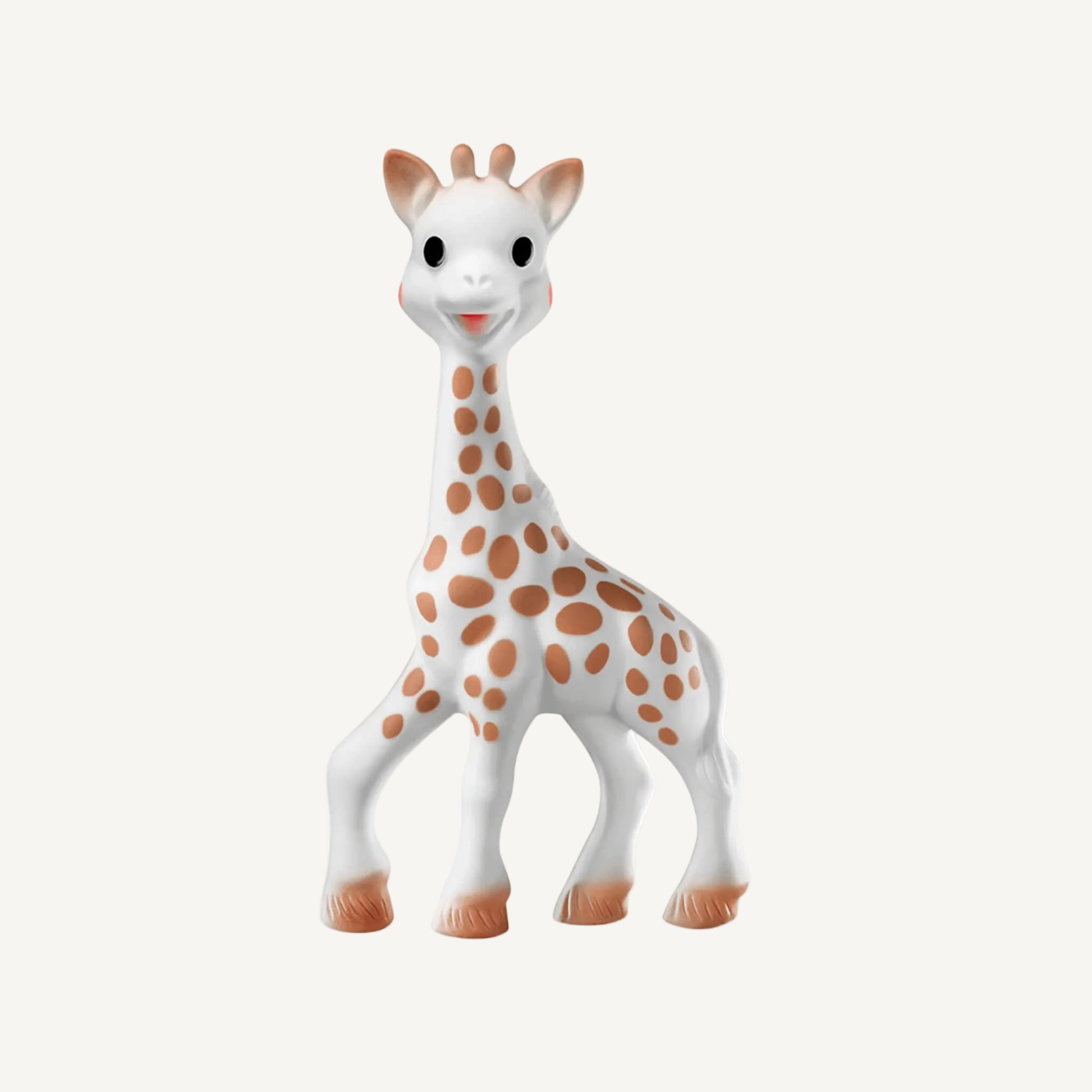 A white natural rubber giraffe-shaped baby teething toy standing upright, with brown spotted markings, rounded horns, and softly textured hooves.