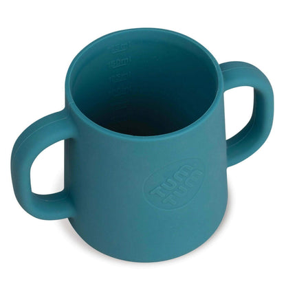 An open blue silicone cup with two handles and internal measurement markings visible inside, showing portion guidance for drinks.