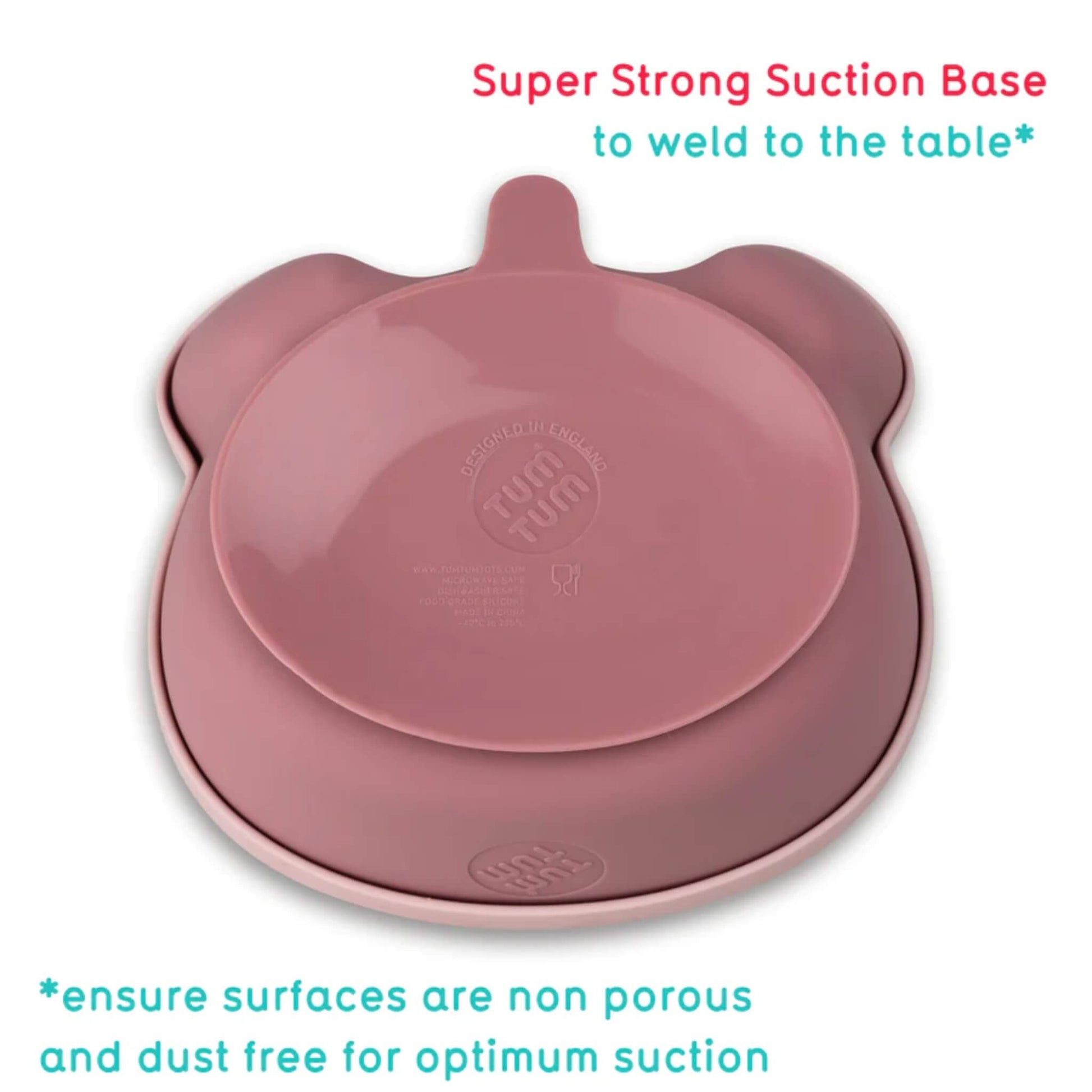 The underside of a pink silicone baby bowl showing a wide suction base designed to grip smooth, non-porous surfaces.