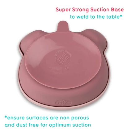 The underside of a pink silicone baby bowl showing a wide suction base designed to grip smooth, non-porous surfaces.