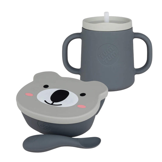 TUM TUM silicone suction bowl with bear-shaped lid, matching spoon and two-handled trainer cup with straw lid, photographed together on a plain background.