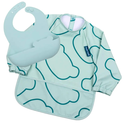 A baby bib and long-sleeve smock set in blue, featuring a cloud pattern and a small blue 'TUM TUM' brand tag, displayed on a clean white background.