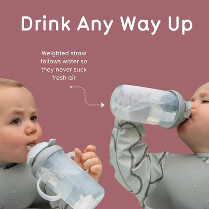 Two babies drinking from handled straw cups held upright and at an angle, showing how the weighted straw follows the liquid.