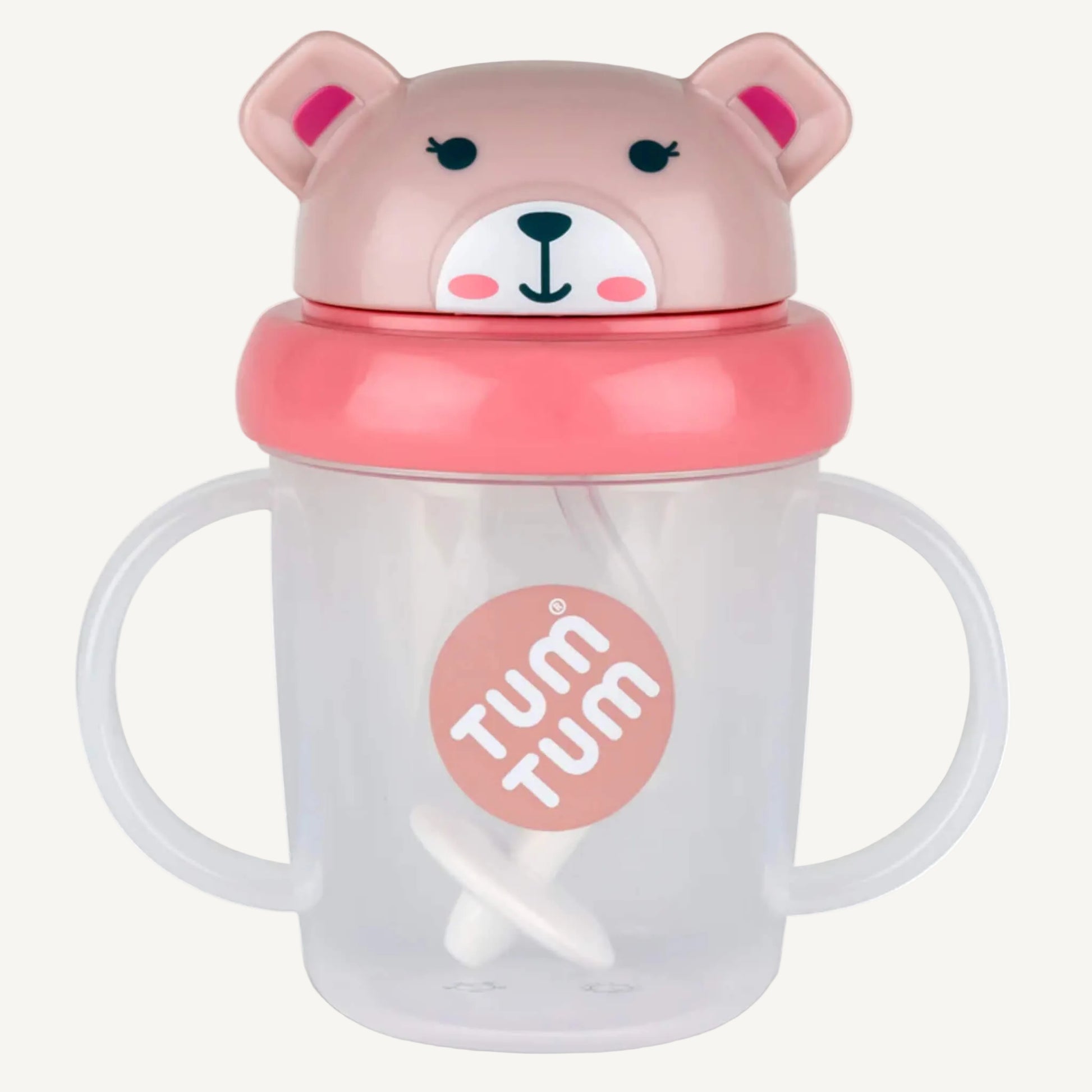 A close-up view of a clear sippy cup with side handles, a weighted straw inside, and a pink bear-shaped lid on top.