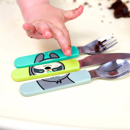 A child using a cutlery set, featuring Stanley Sloth handles on the spoon, knife, and fork. Designed for easy grip and self-feeding, with a fun and colourful design.