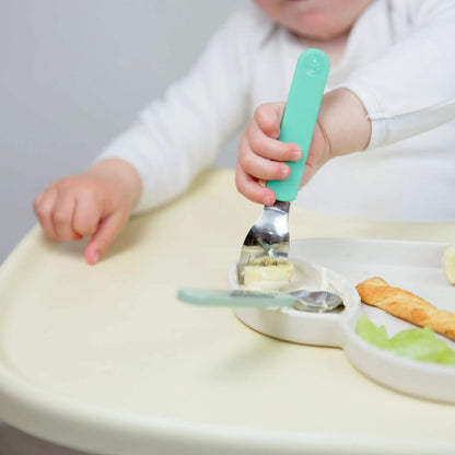 A child using a toddler fork to eat, holding the fork with a comfortable grip. Designed for self-feeding, featuring Stanley Sloth handles.