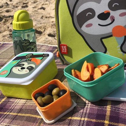 A water bottle with Stanley sloth character design, alongside matching snack boxes and lunch bag, placed on a blanket at the beach, perfect for kids' meals.