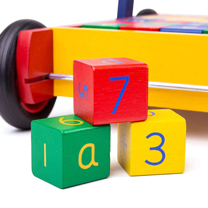 Three loose blocks—red, green and yellow—showing the numbers 7, 6 and 3 and the letters “s”, “a” and a plus symbol.