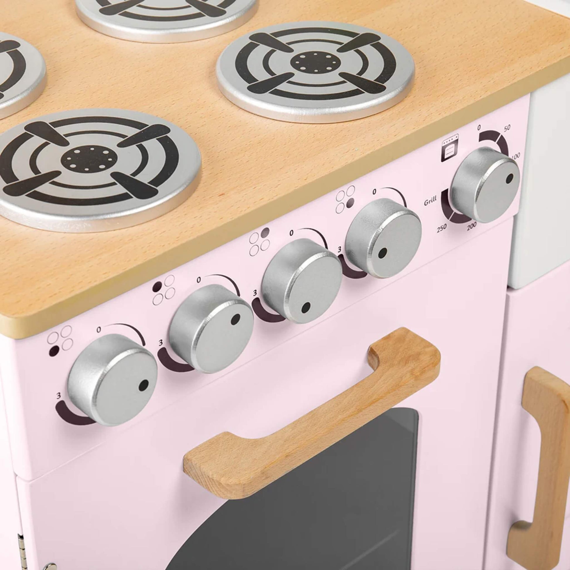Close-up of the oven dials with printed numbers and grill settings, plus a wooden handle on the oven door below.