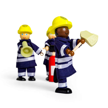 Close-up of three firefighter dolls, with one figure in the foreground holding a wooden axe and smiling.