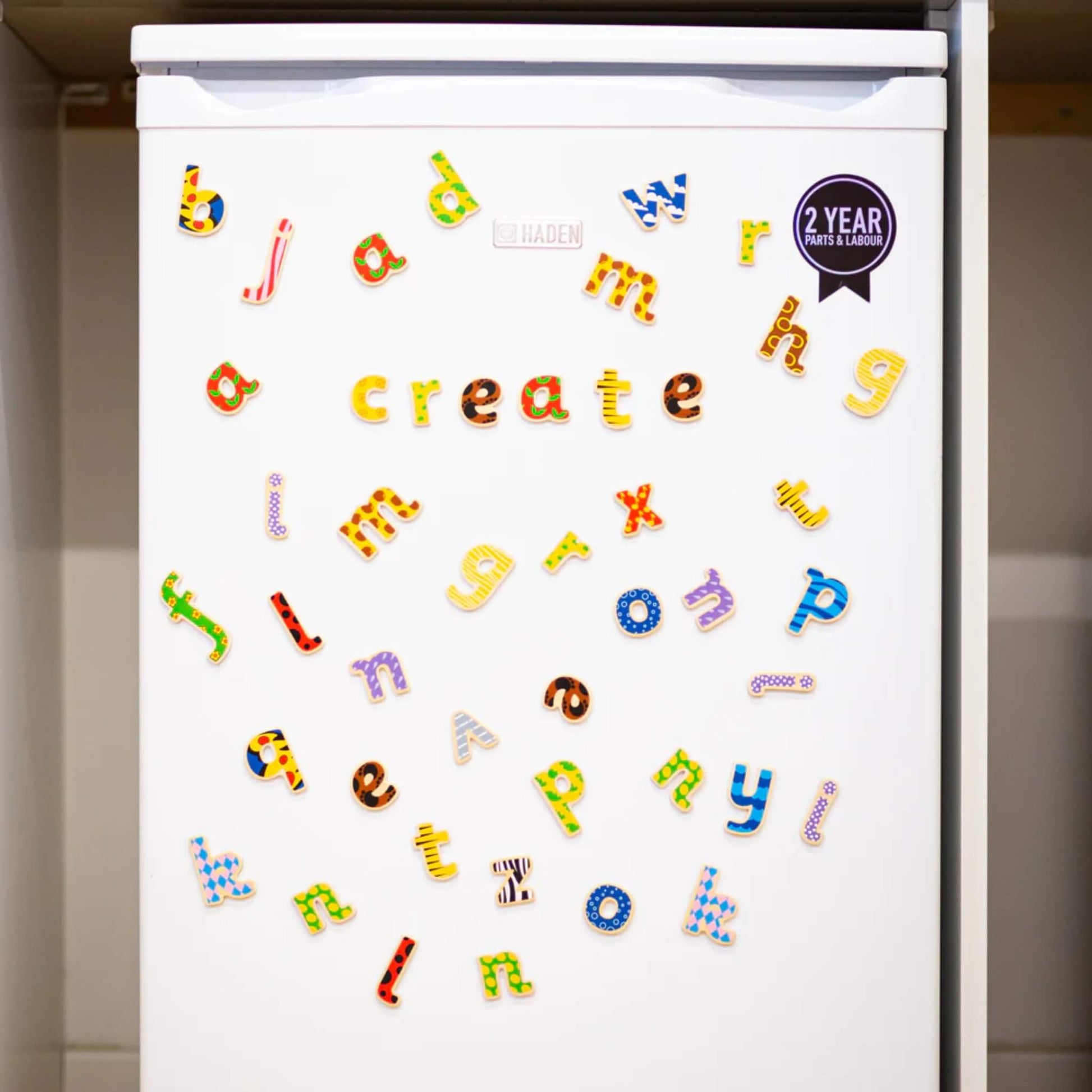 White refrigerator with colourfulTidlo lowercase letter magnets spelling out 'create'.