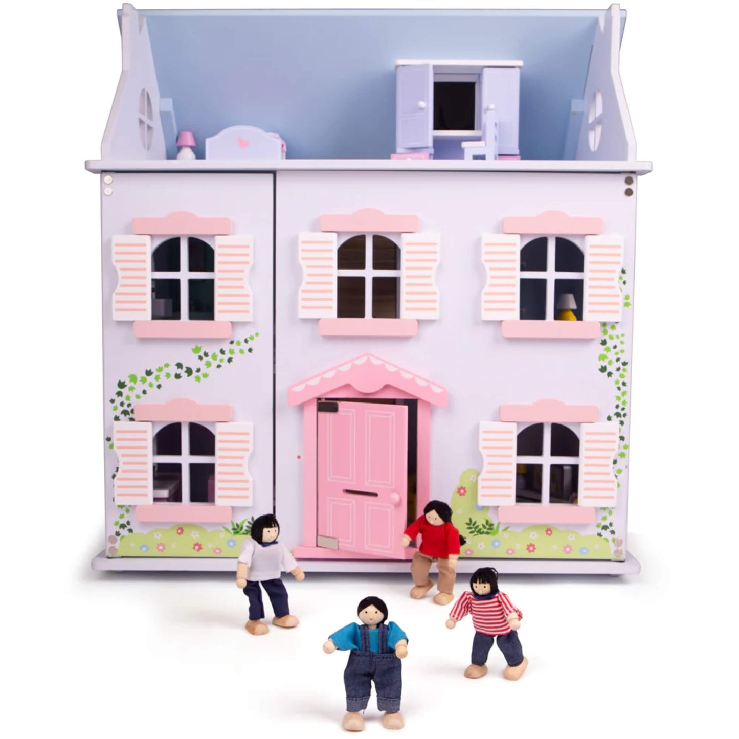 Wooden doll family placed in front of a pastel pink-and-purple dollhouse with shutter windows and floral details, ready to move in.