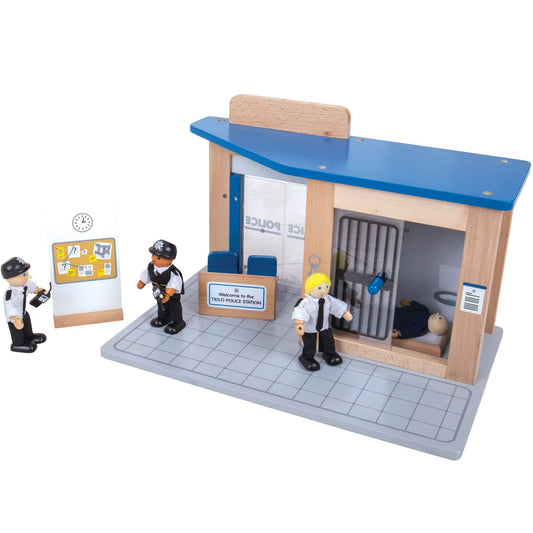 Back view of the Tidlo Police Station showing three police figures, a suspect board, and a prisoner figure inside the built-in jail with sliding bar doors.