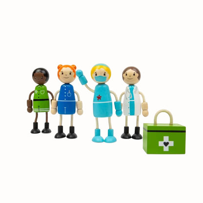 Four wooden healthcare figures standing beside a green first aid kit, including doctor, nurse, surgeon and paramedic.