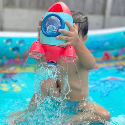 A child in a paddling pool holding the rocket high as water pours down in a dome shape from the spinning base.