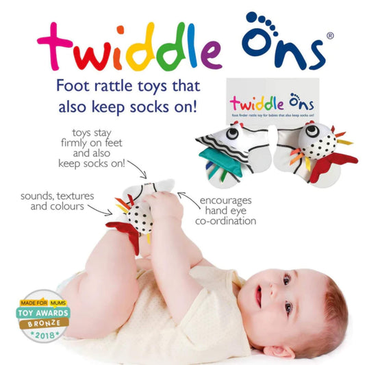 Baby lying on a soft surface wearing foot rattle toys, lifting feet to explore textured fabric shapes with hands and feet.