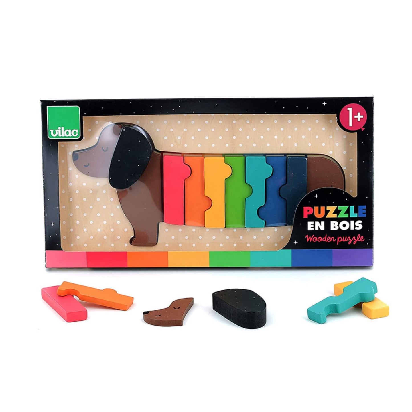 A boxed wooden dachshund puzzle with the assembled pieces visible through the packaging window, and additional loose pieces placed in front of the box.