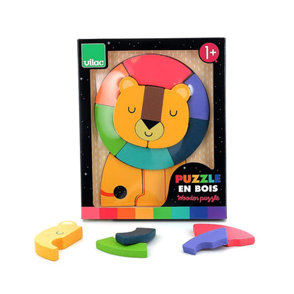 A boxed wooden lion puzzle with the assembled pieces visible through the packaging window, and additional loose pieces placed in front of the box.