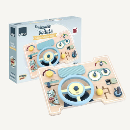 Packaging box showing wooden car activity board with illustrated dashboard features including wheel, gauges and interactive controls.